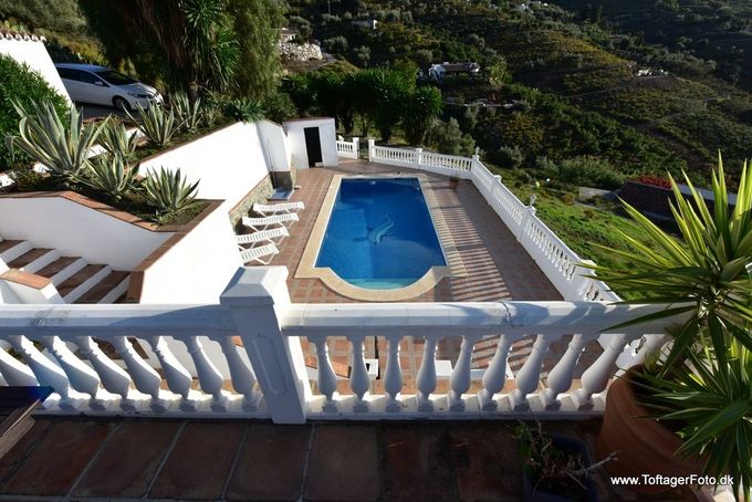 Husets anden terrasse med adgang til pool og gæstehus.
På terrassen er der solsenge og undedørs bruser
